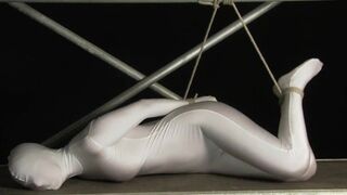 Babe wrapped in white zentai suit enjoys to be bondaged to a metal pole